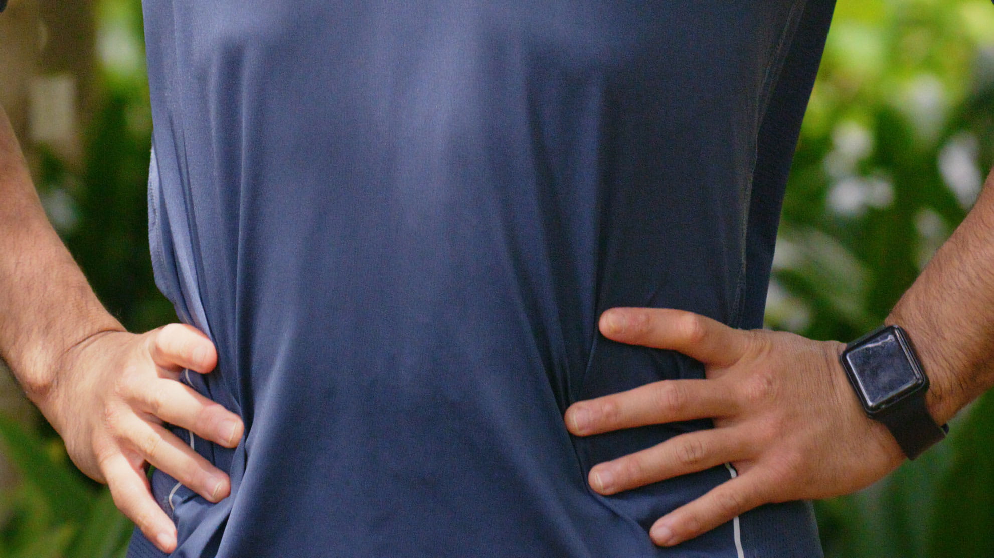 Person standing with hands on hips.