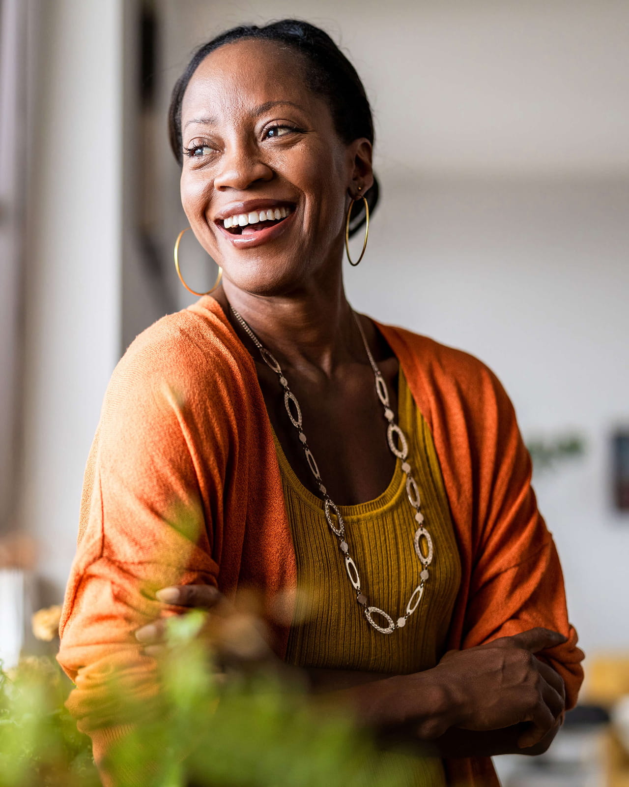 A woman smiles as she looks out a window.